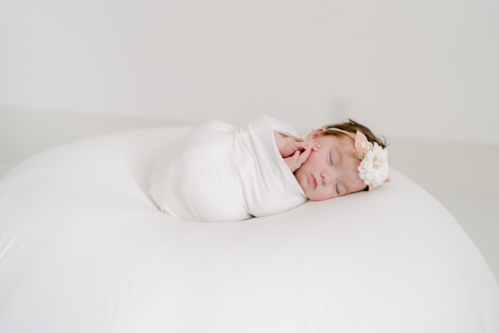 portrait of a baby by herself in an all white photography studio