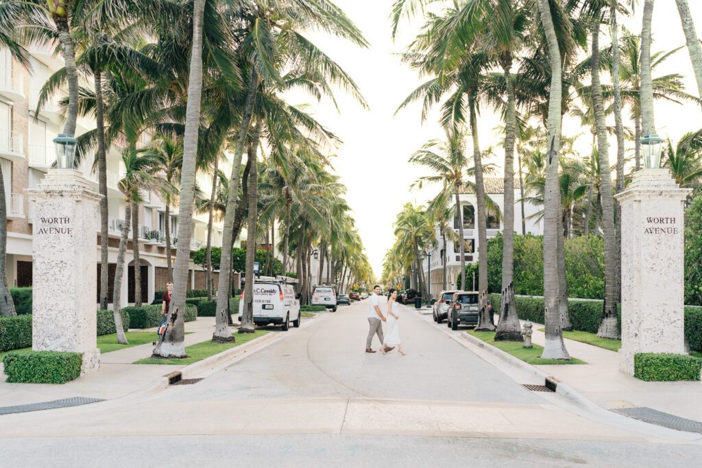 pregnant woman and husband crossing the street at worth avenue in palm beach island, florida